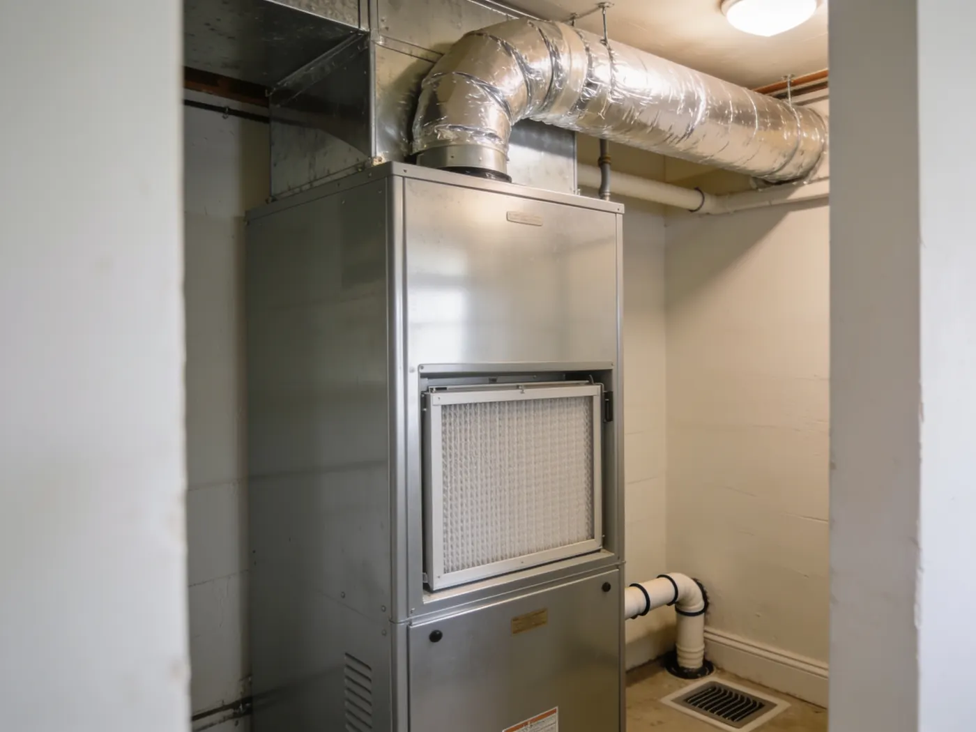 A clean vertical air handler cabinet with a neatly fitted filter access panel and insulated plenum above.